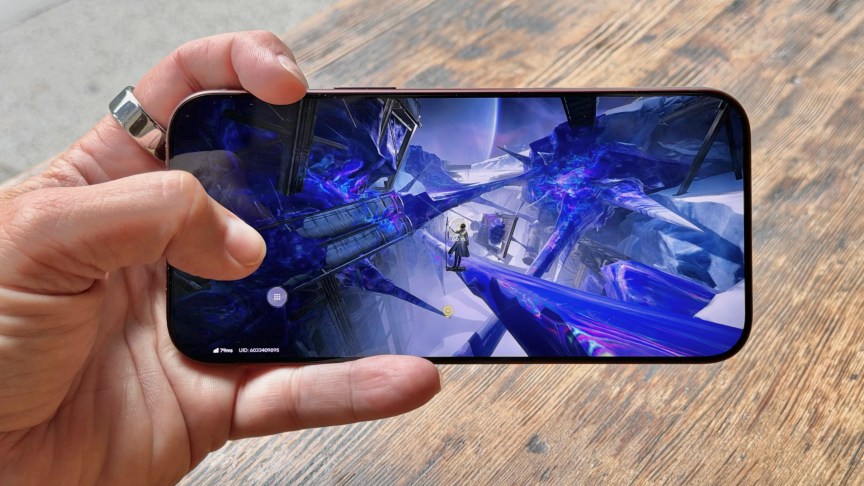 A hand holding the iPhone 18 Pro Max while playing a video game onscreen