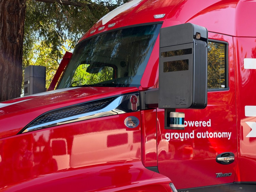 A black rectangular sensor pod at the front of a semi truck