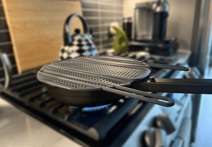splatter guard on skillet over flame