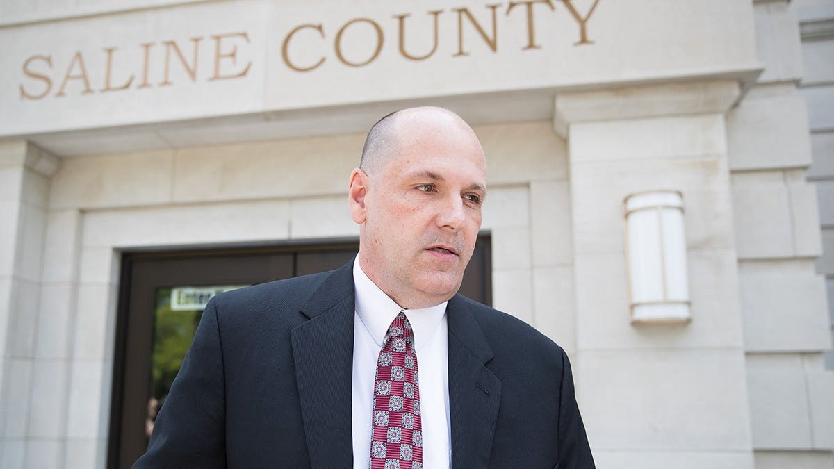 Corey O'Brien of the Nebraska Attorney General's Office speaks to media outside a courthouse.