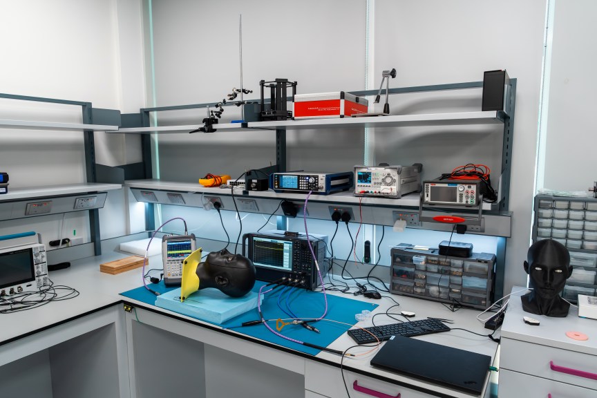 The Xpanceo lab with various monitors on shelving and black mannequin heads wearing smart contact lenses.