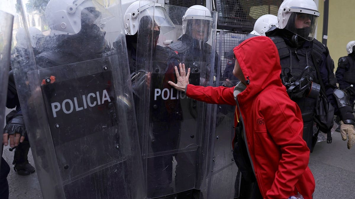 Protester pushes riot police officer's shield during demonstration in Tirana.