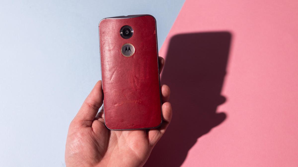 A hand holding a leather-clad phone