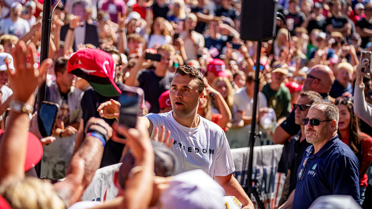 Charlie Kirk surrounded by a large audience, tosses hats to the crowd shortly before his assassination in Utah