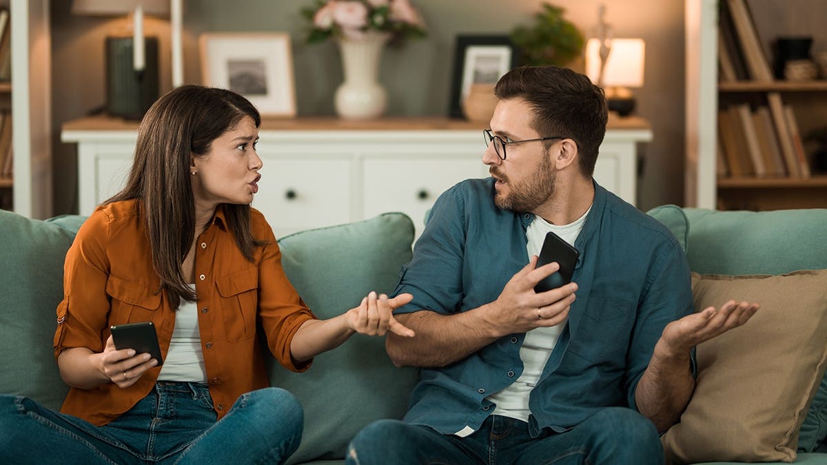 Young couple argues over text messages on boyfriend's phone.