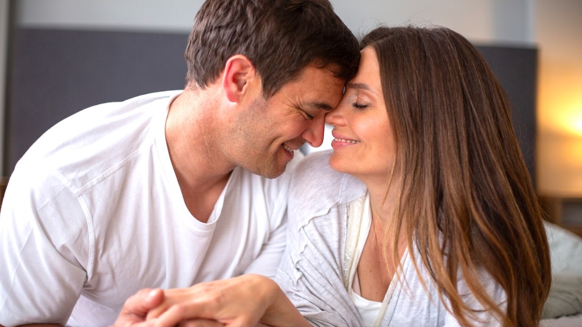 Couple snuggling in bed