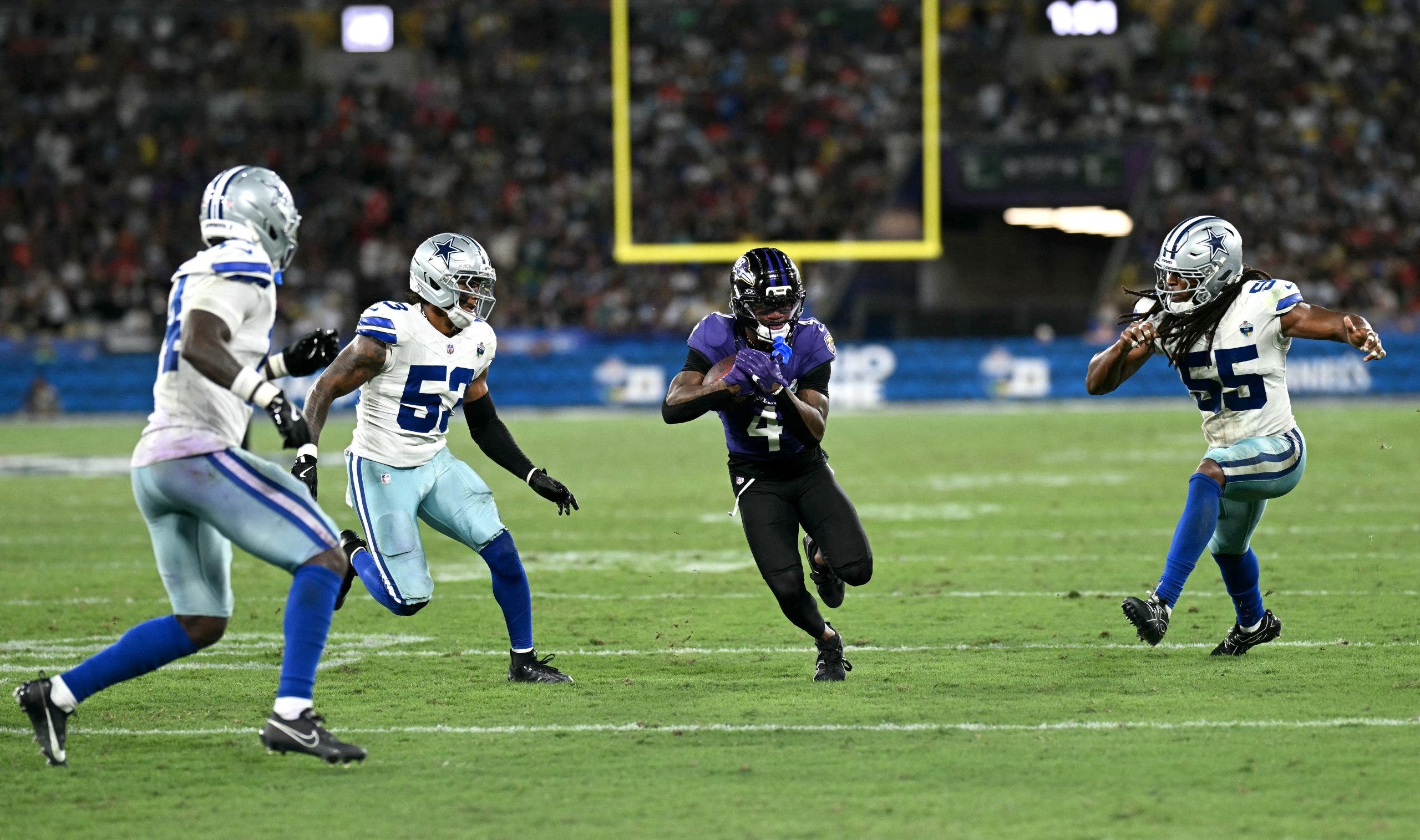 The field conditions for Sunday's Ravens-Cowboys game were less than ideal, with players taking extra steps to prepare for the field at Rio de Janeiro. (Photo by MAURO PIMENTEL / AFP via Getty Images)