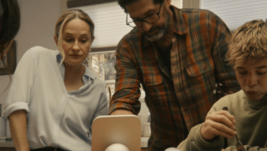 A family gathers around a HomeView smart home device in the kitchen.