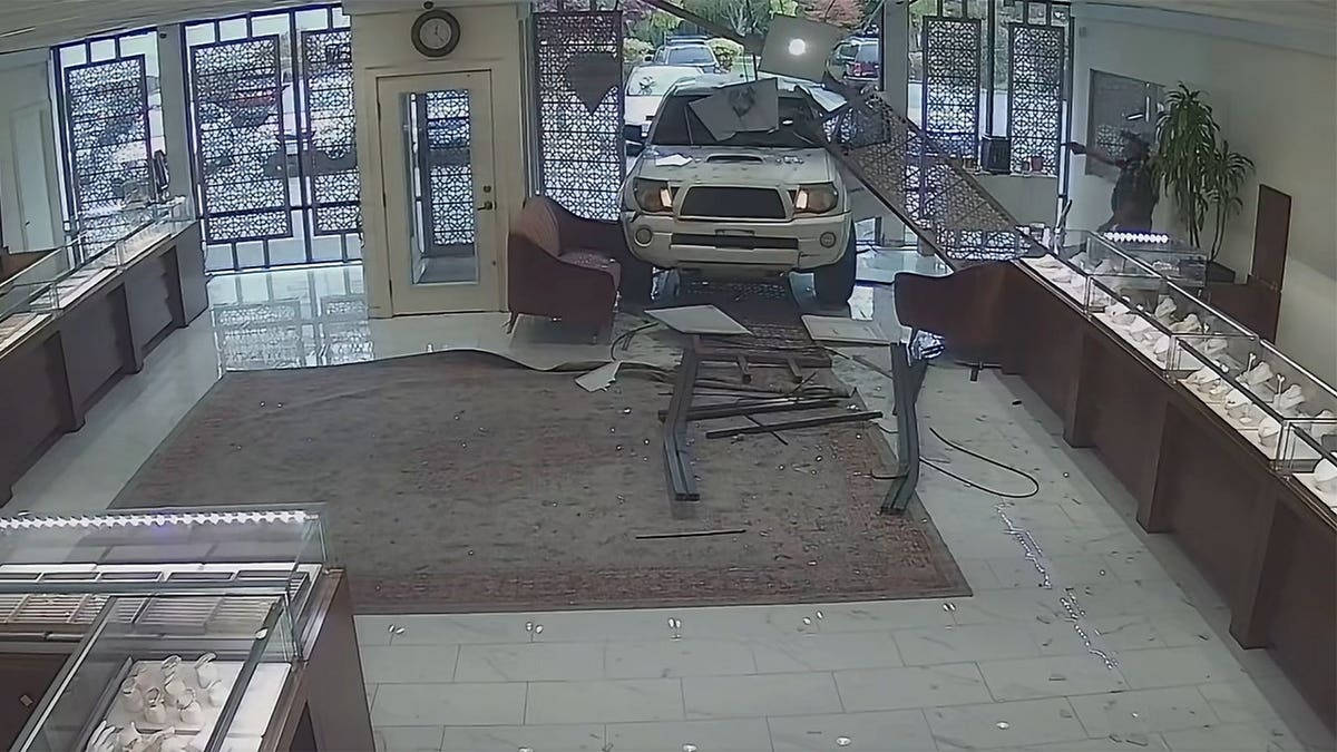A man points a gun as suspects flee the scene.