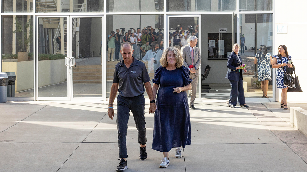 Martin and Debra Robinson hold hands as they walk outside a court building in Mexico