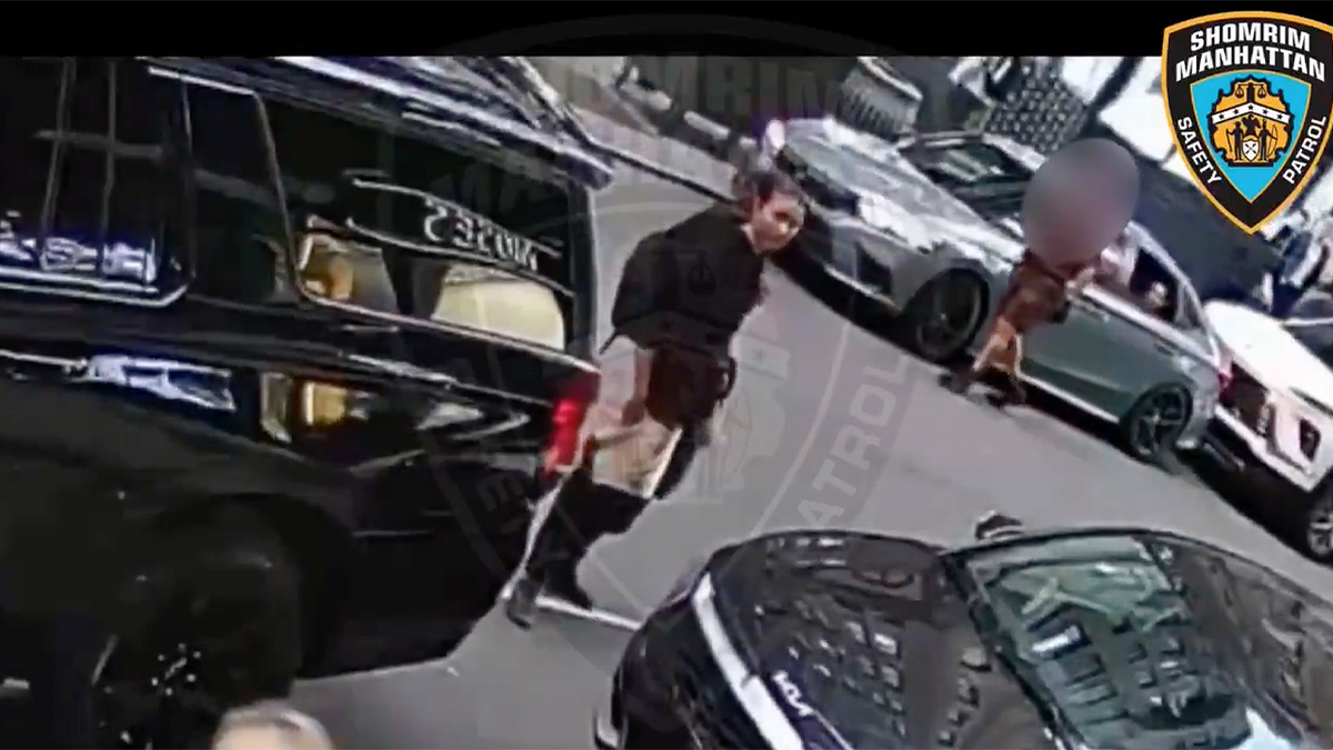 Surveillance image shows a woman beside a parked black SUV in Manhattan’s Diamond District
