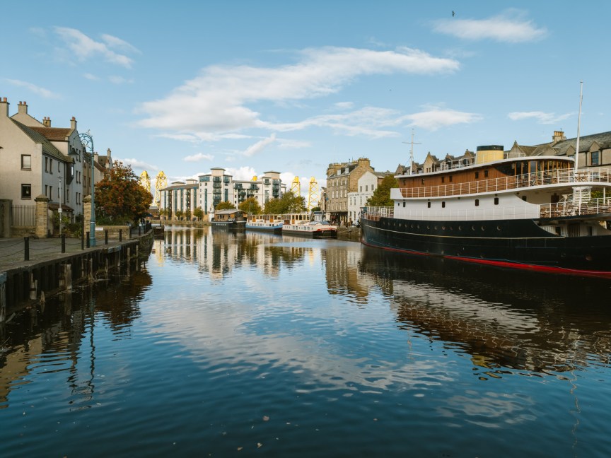Image of a river with buildings and a boat