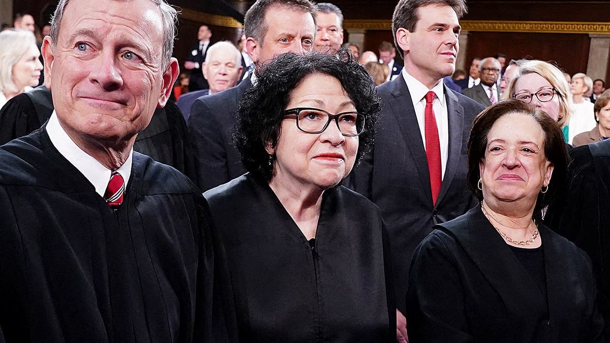 Chief Justice John Roberts and Associate Justices Sonia Sotomayor, Elena Kagan, Neil Gorsuch, Brett Kavanaugh and Ketanji Brown Jackson stand in the House Chamber.