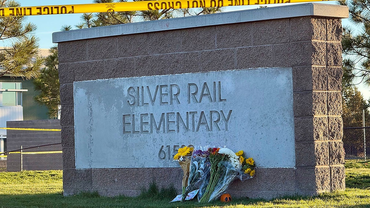 Flowers are placed beside a sign at Silver Rail Elementary School in Bend, Ore., on Friday, Oct. 16, 2026, a day after a deadly shooting.