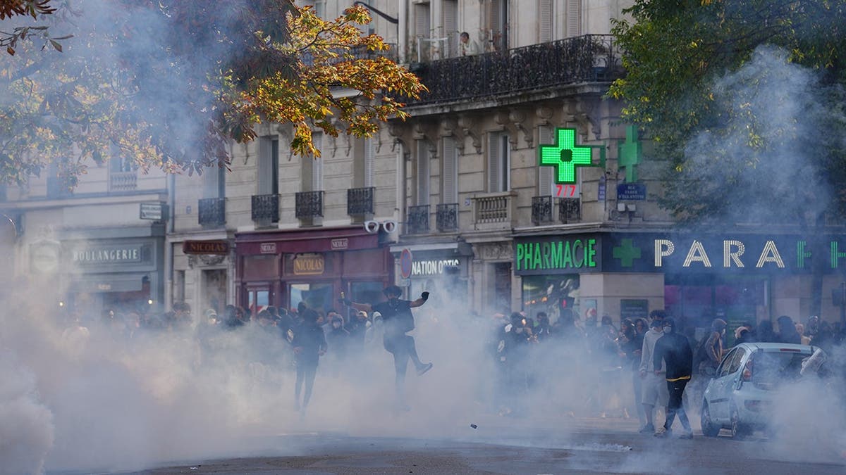 A student kicks a tear gas canister during a protest in Paris.