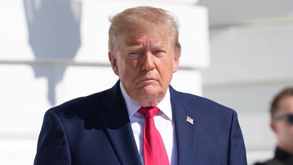 President Donald Trump walking across the South Lawn of the White House toward reporters.
