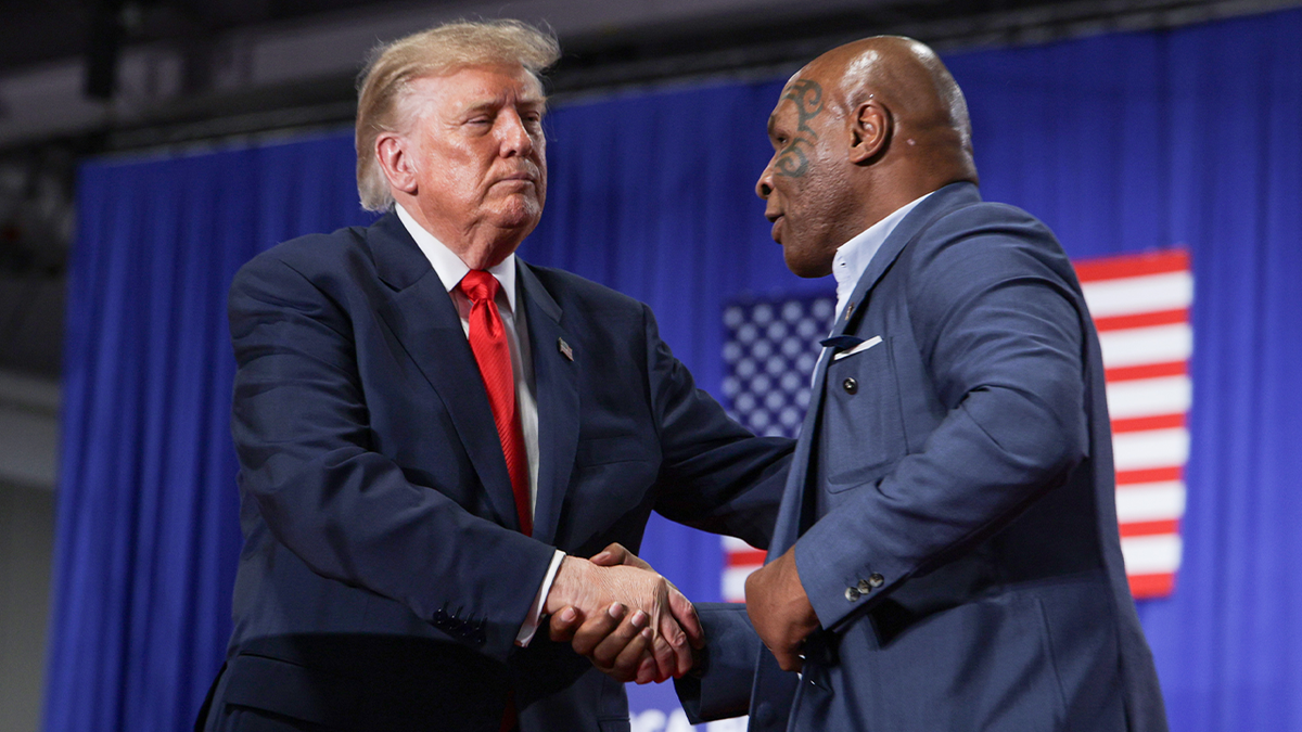 U.S. President Donald Trump (L) shakes hands with Former professional boxer Mike Tyson after he was introduced during an election rally at the Oncenter on October 09, 2026 in Syracuse, New York. Trump is in New York campaigning for local Republican candidates ahead of the midterm elections.