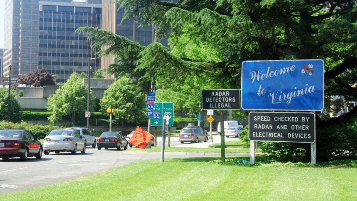 Virginia welcome sign posted in grass near Lee Highway intersection in Rosslyn