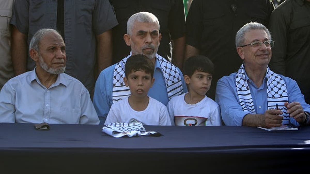 Yahya Sinwar, Mahmoud al-Zahar and Mustafa Barghouti stand together at a rally in Gaza City.