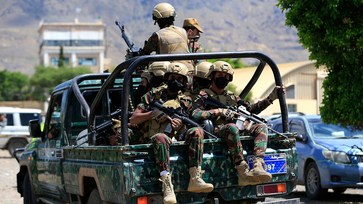 Houthi armed forces patrol as Yemeni prisoners loyal to Houthi authorities arrive in Sanaa